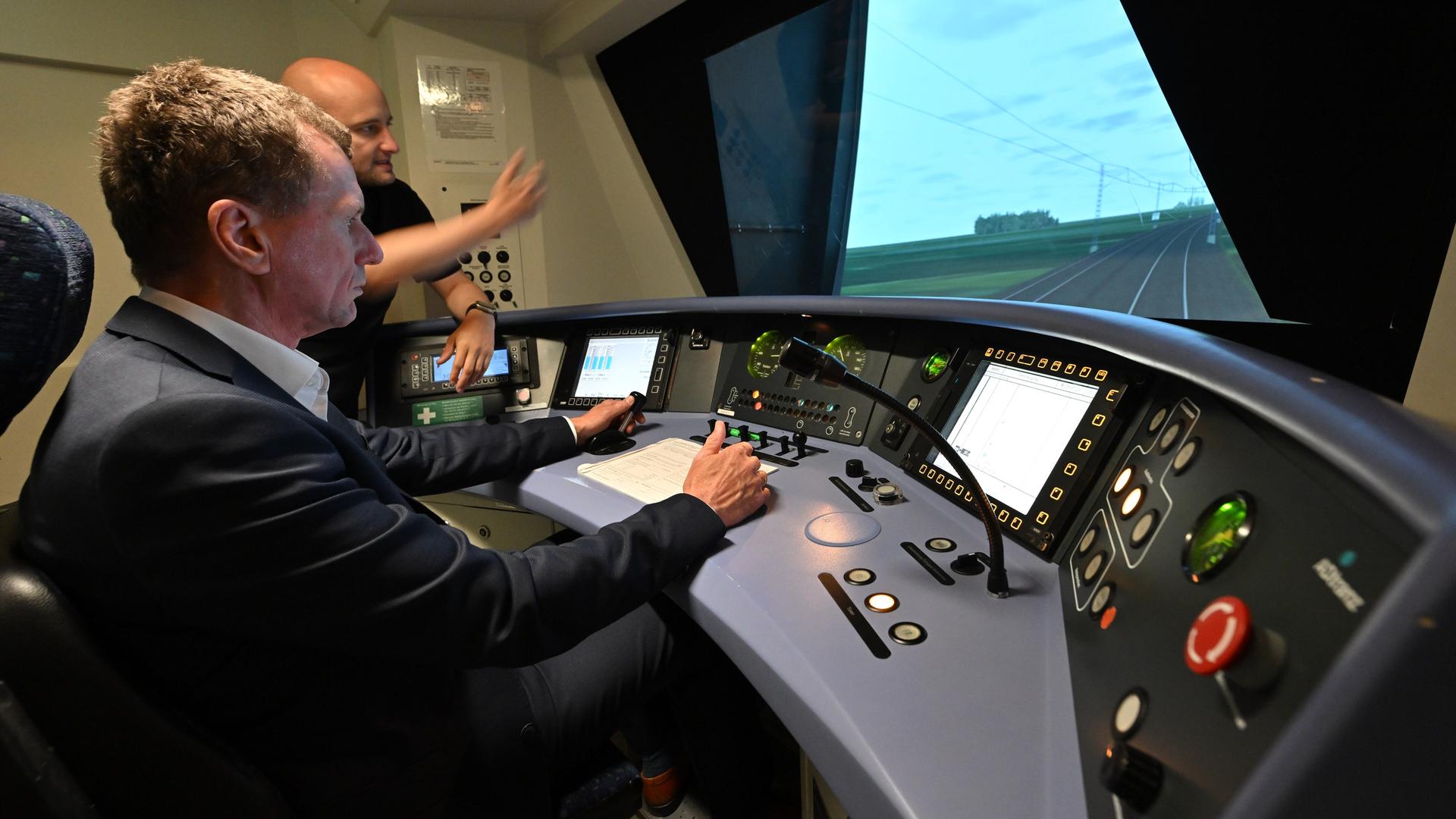 Ein Trainer der Deutschen Bahn unterrichtet in einem Fahrsimulator eines Lokführers
