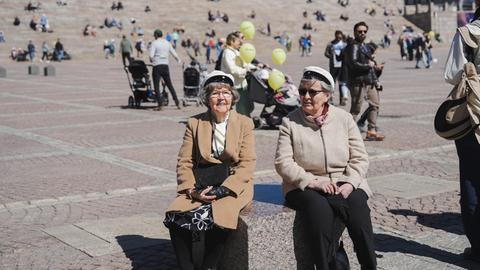 Rentnerinnen tragen weiße Hüte, wie sie am 1. Mai in Finnland Tradition sind. Rentnerinnen tragen weiße Hüte, wie sie am 1. Mai in Finnland Tradition sind.