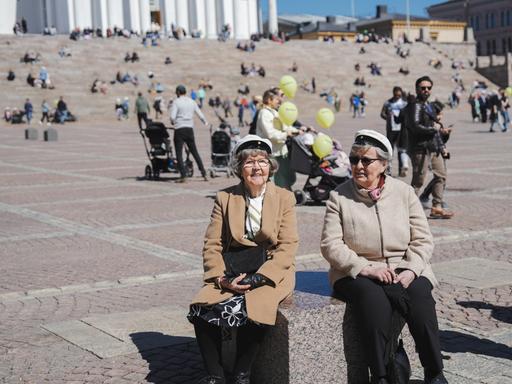 Rentnerinnen tragen weiße Hüte, wie sie am 1. Mai in Finnland Tradition sind. Rentnerinnen tragen weiße Hüte, wie sie am 1. Mai in Finnland Tradition sind.