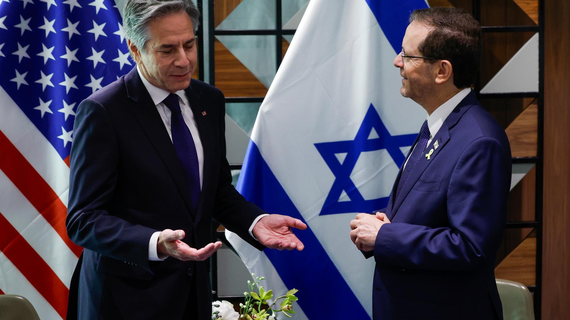 US-Außenminister Antony Blinken (l), und der israelische Präsident Isaac Herzog in Tel Aviv. Im Hintergrund sind die Nationalflaggen. 