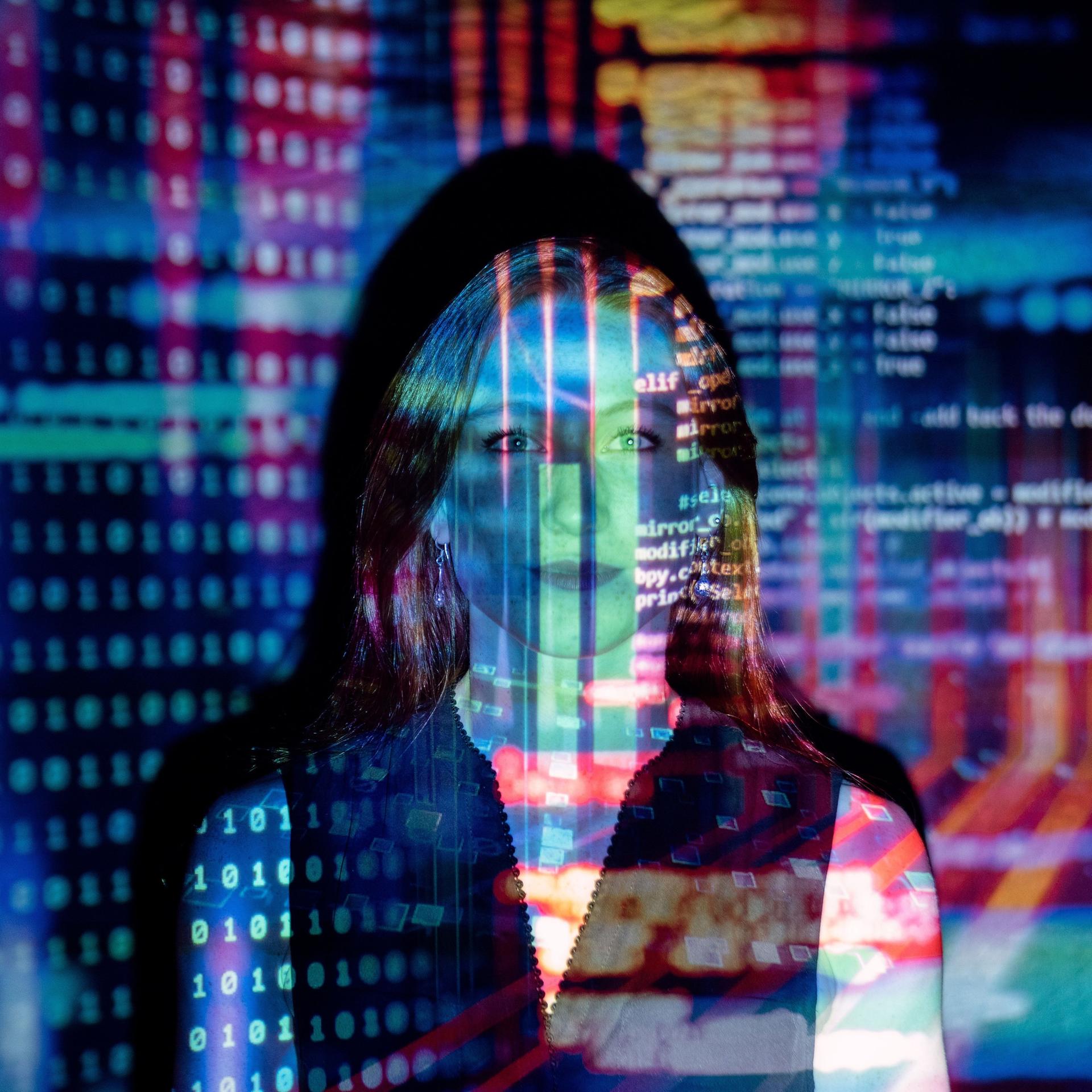 Zu sehen ist eine Frau, auf die digitale Codes projeziert werden. 