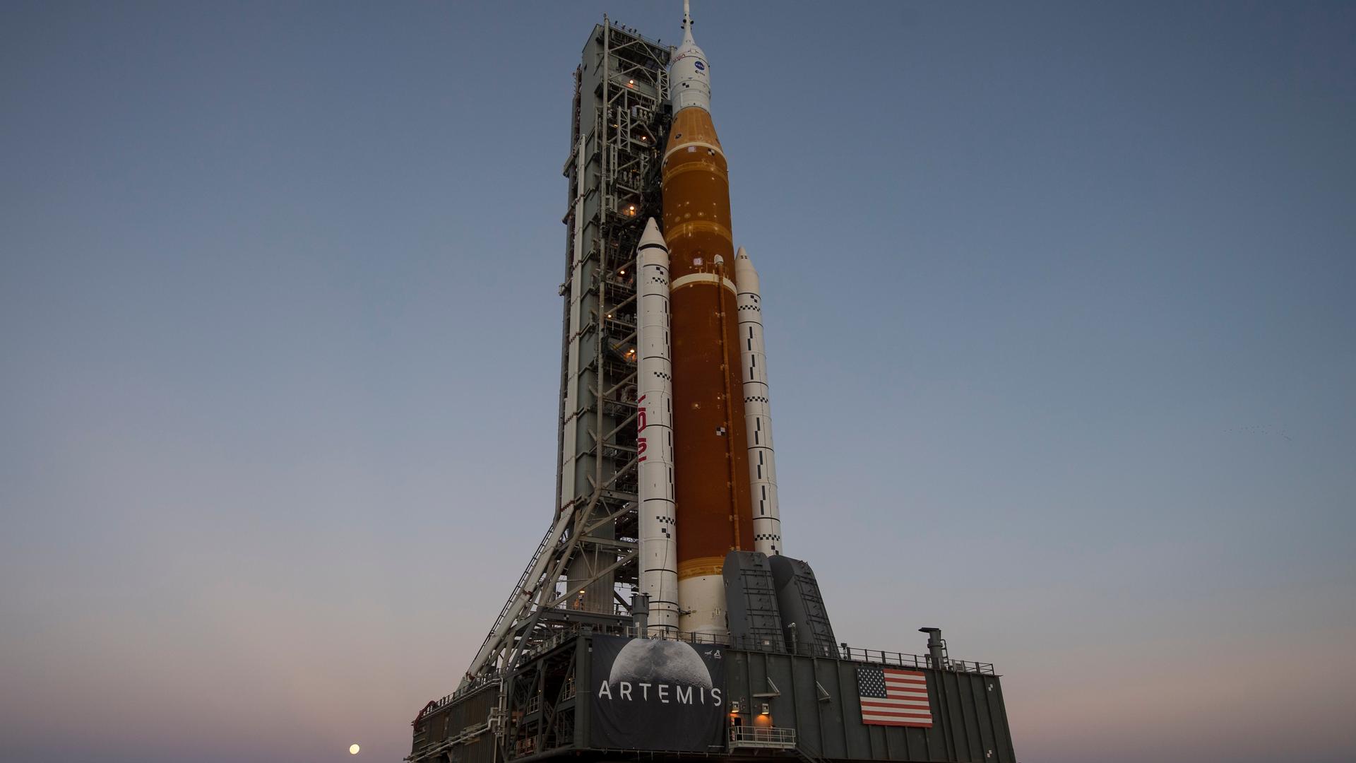 NASA Space Launch System Rakete mit dem Rollout des Orion-Raumfahrzeugs vor Abendhimmel.