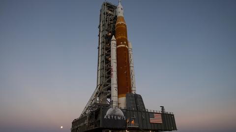 NASA Space Launch System Rakete mit dem Rollout des Orion-Raumfahrzeugs vor Abendhimmel.