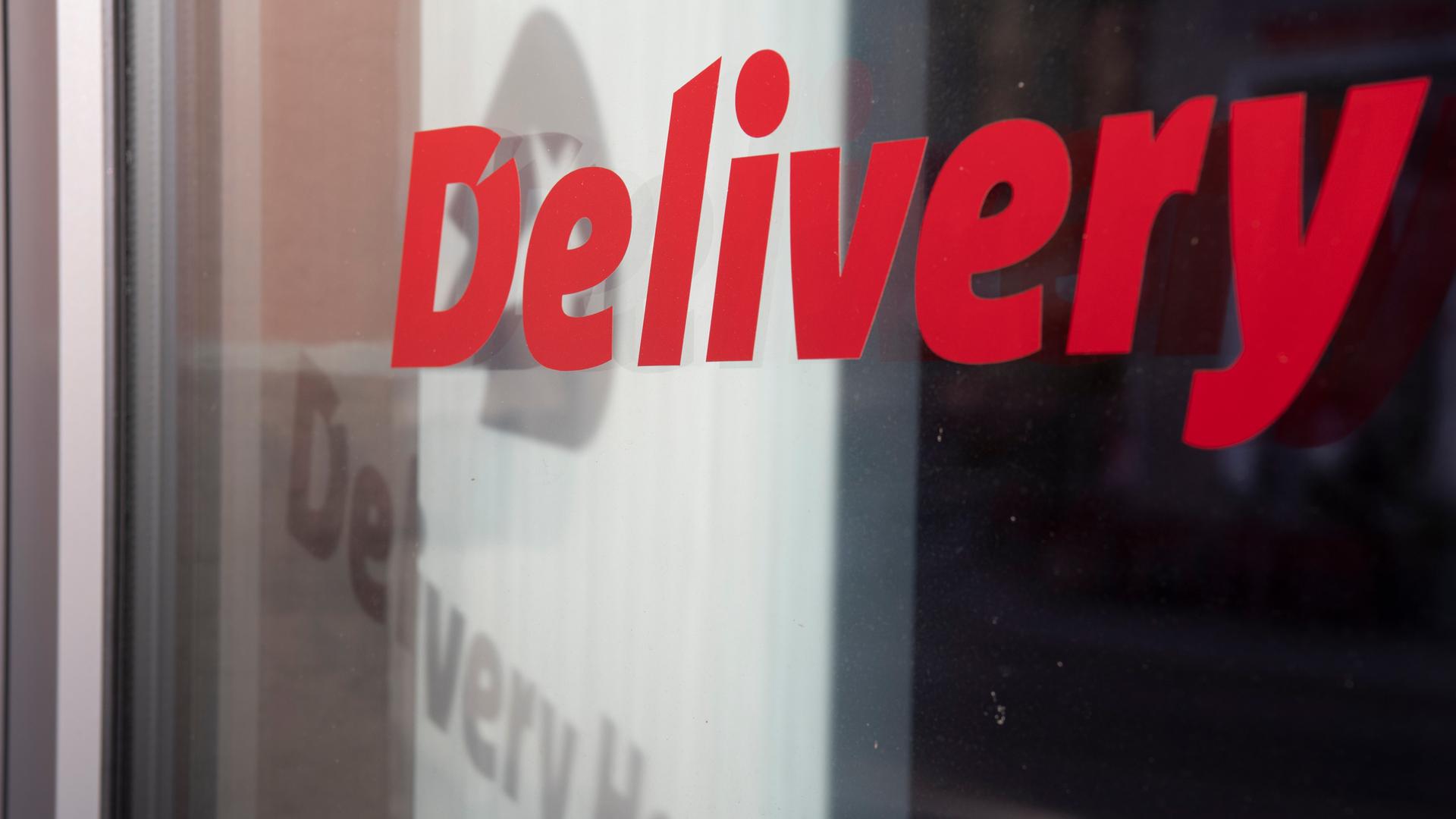 Das Logo und der Schriftzug des Essenslieferdienstes Delivery Hero spiegelt sich in einer Fensterscheibe am Firmensitz des Unternehmens in Berlin. Das Logo und der Schriftzug des Essenslieferdienstes Delivery Hero spiegelt sich in einer Fensterscheibe am Firmensitz des Unternehmens in Berlin.