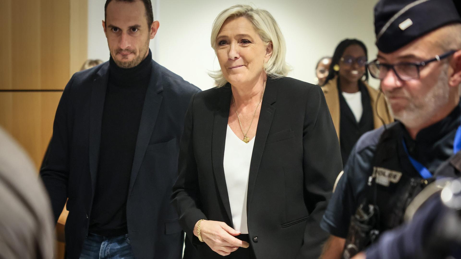 Die Politikerin Marine Le Pen von der rechtsnationalen Partei Rassemblement National in dunkler Kleidung und mit ernstem Gesicht auf dem Weg in den Gerichtssaal in Paris.