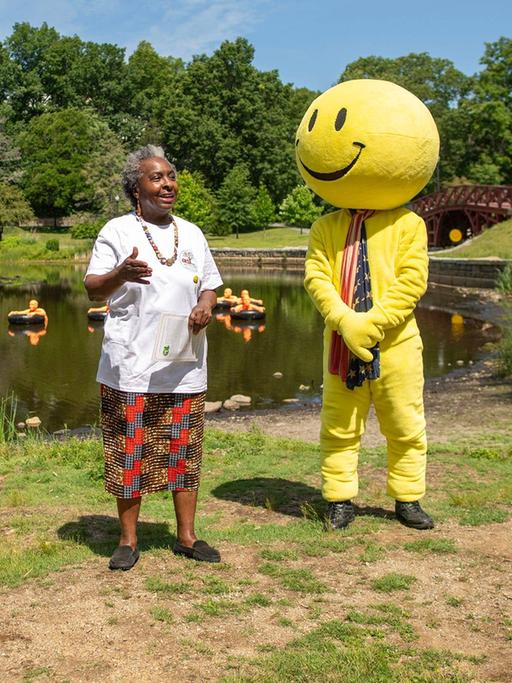 Drei Frauen und eine als Smiley verkleidete Person auf der Wiese