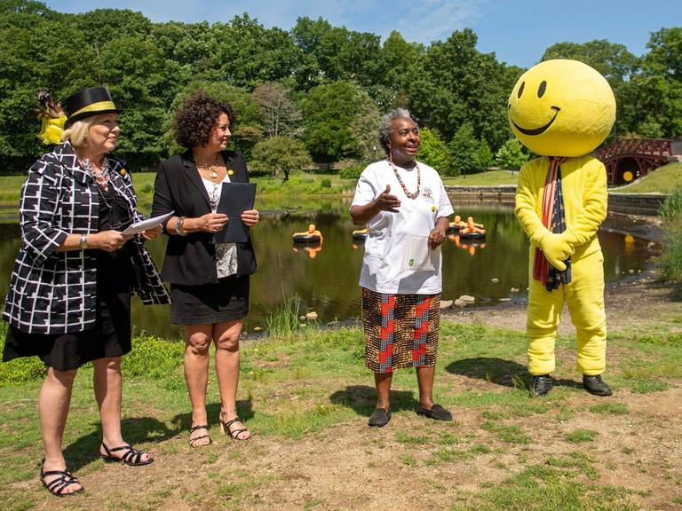 Drei Frauen und eine als Smiley verkleidete Person auf der Wiese