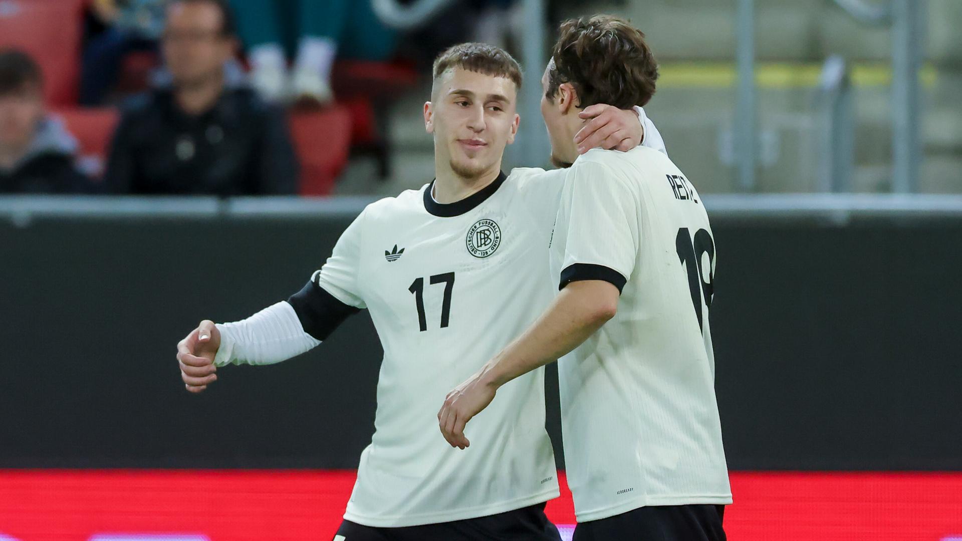 Brajan Gruda (l.) legt seinen linken Arm um den Hals von Rocco Reitz (r.).