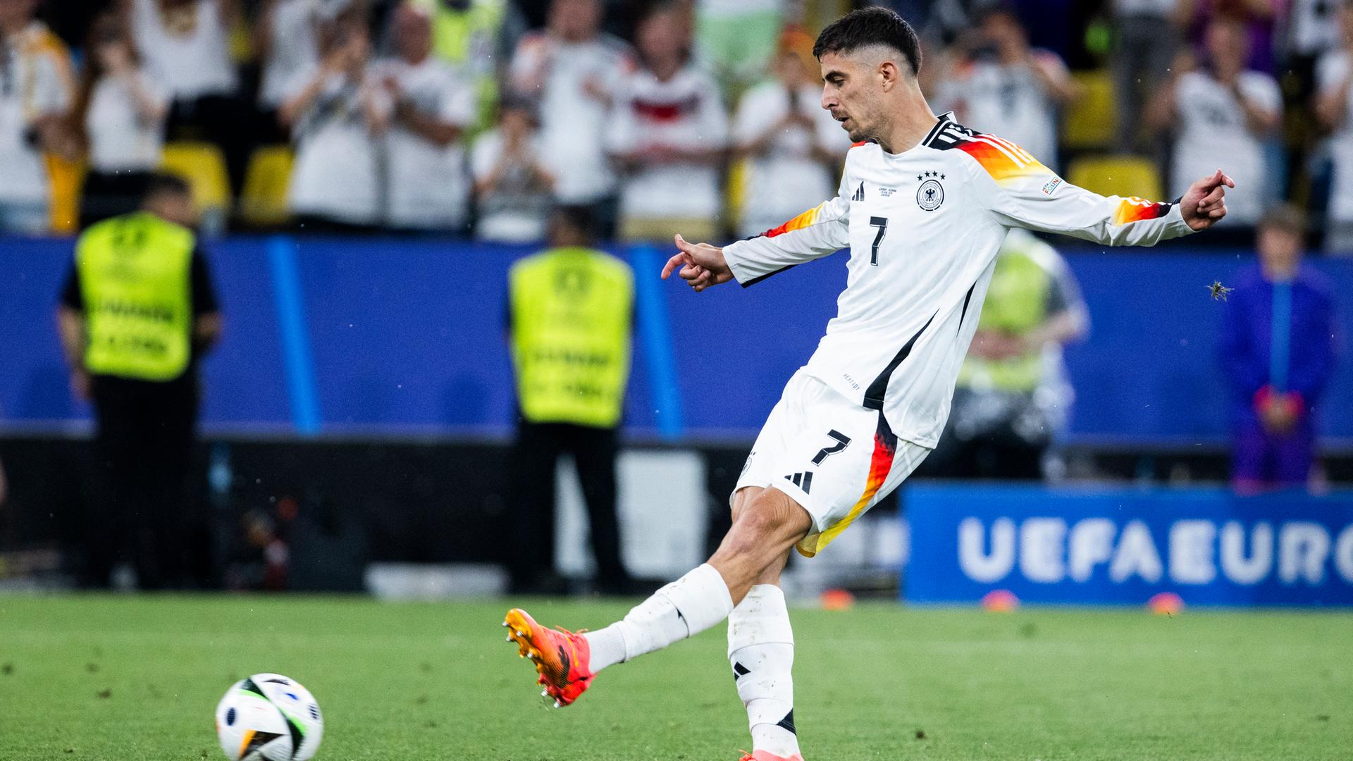 Kai Havertz hat den Ball gerade geschossen. Der Ball fliegt in Richtung Tor.