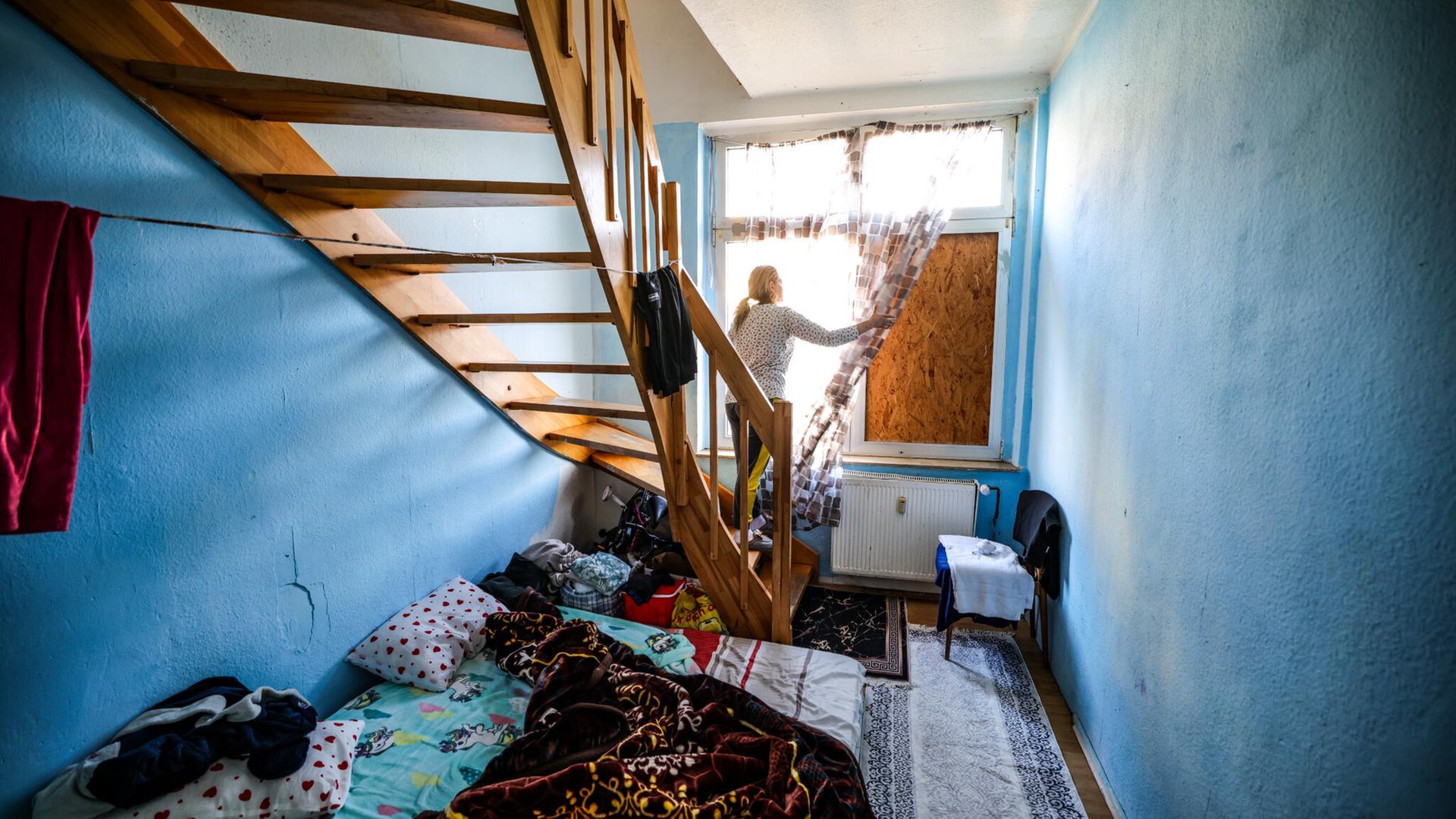 Eine Frau aus Bulgarien steht in einem Zimmer ihrer Wohnung in einer Dortmunder Schrottimmobilie.