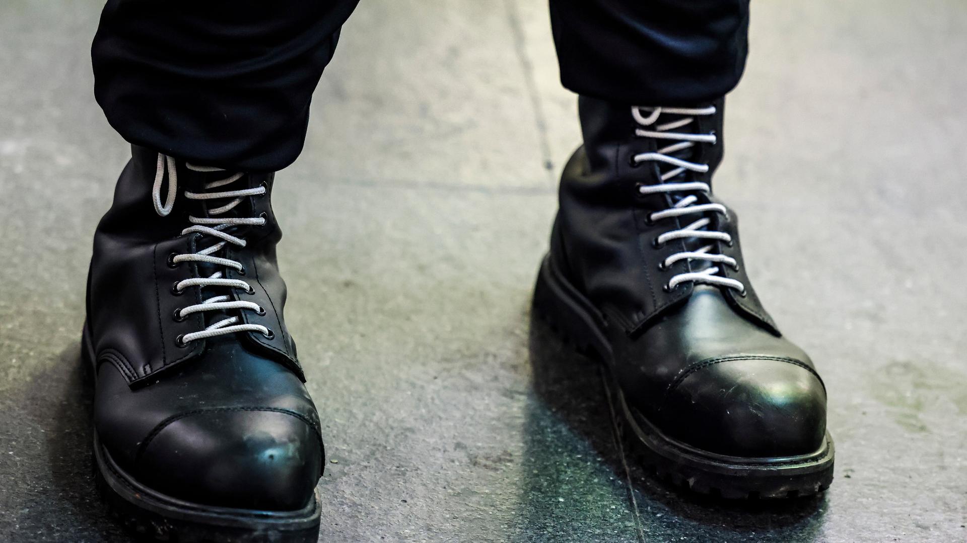 Ein Teilnehmer einer rechtsextremen Kundgebung trägt schwarze Springerstiefel mit weißen Schnürriemen. Ein Teilnehmer einer rechtsextremen Kundgebung trägt schwarze Springerstiefel mit weißen Schnürriemen.