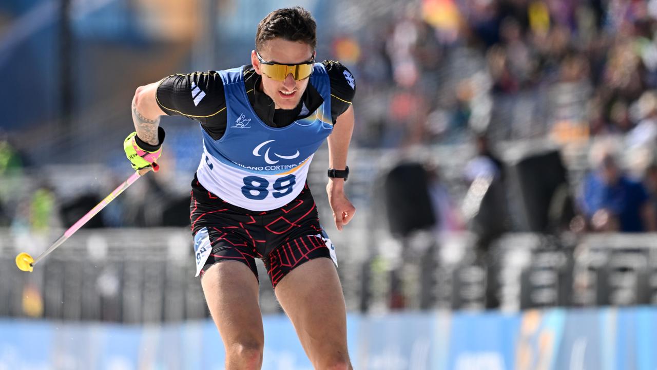 Ein Mann in Shirt und kurzer Hose während eines Ski-Wettkampfes in der Loipe