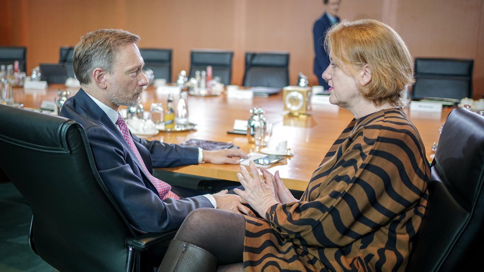 Christian Lindner (FDP), Bundesminister der Finanzen, und Lisa Paus (Bündnis 90/Die Grünen), Bundesministerin für Familie, Senioren, Frauen und Jugend, nehmen an der Sitzung des Bundeskabinetts im Bundeskanzleramt teil. Sie sitzen nebeneinander, schauen sich an und sind im Gespräch. 