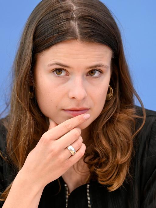 Eine junge Person sitzt an einem Tisch.