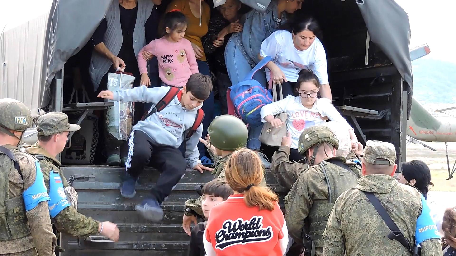 In der Region stationierte russische Soldaten evakuieren armenische Zivilisten aus Bergkarabach .
