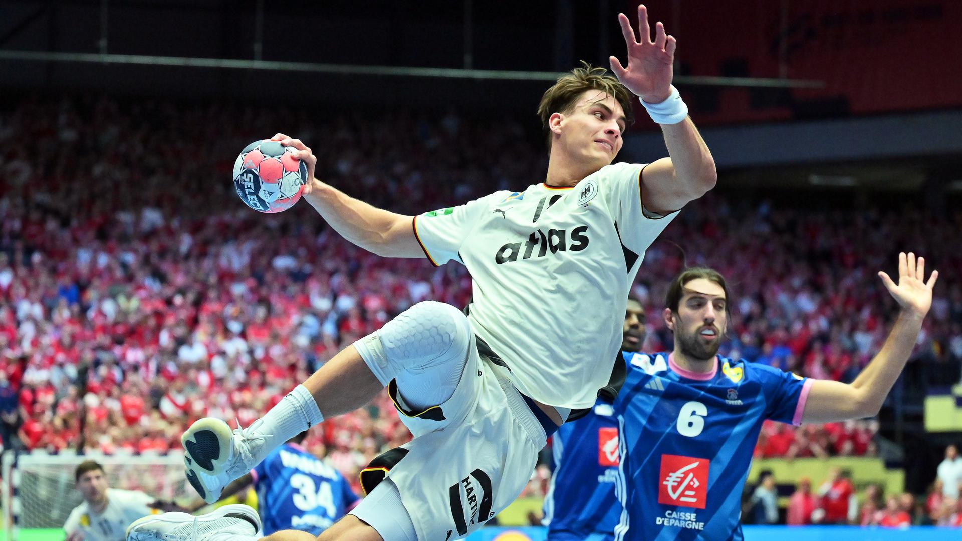 Spieler Julian Köster springt in die Luft und wirft dabei den Ball auf das Tor.