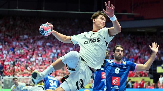 Spieler Julian Köster springt in die Luft und wirft dabei den Ball auf das Tor.
