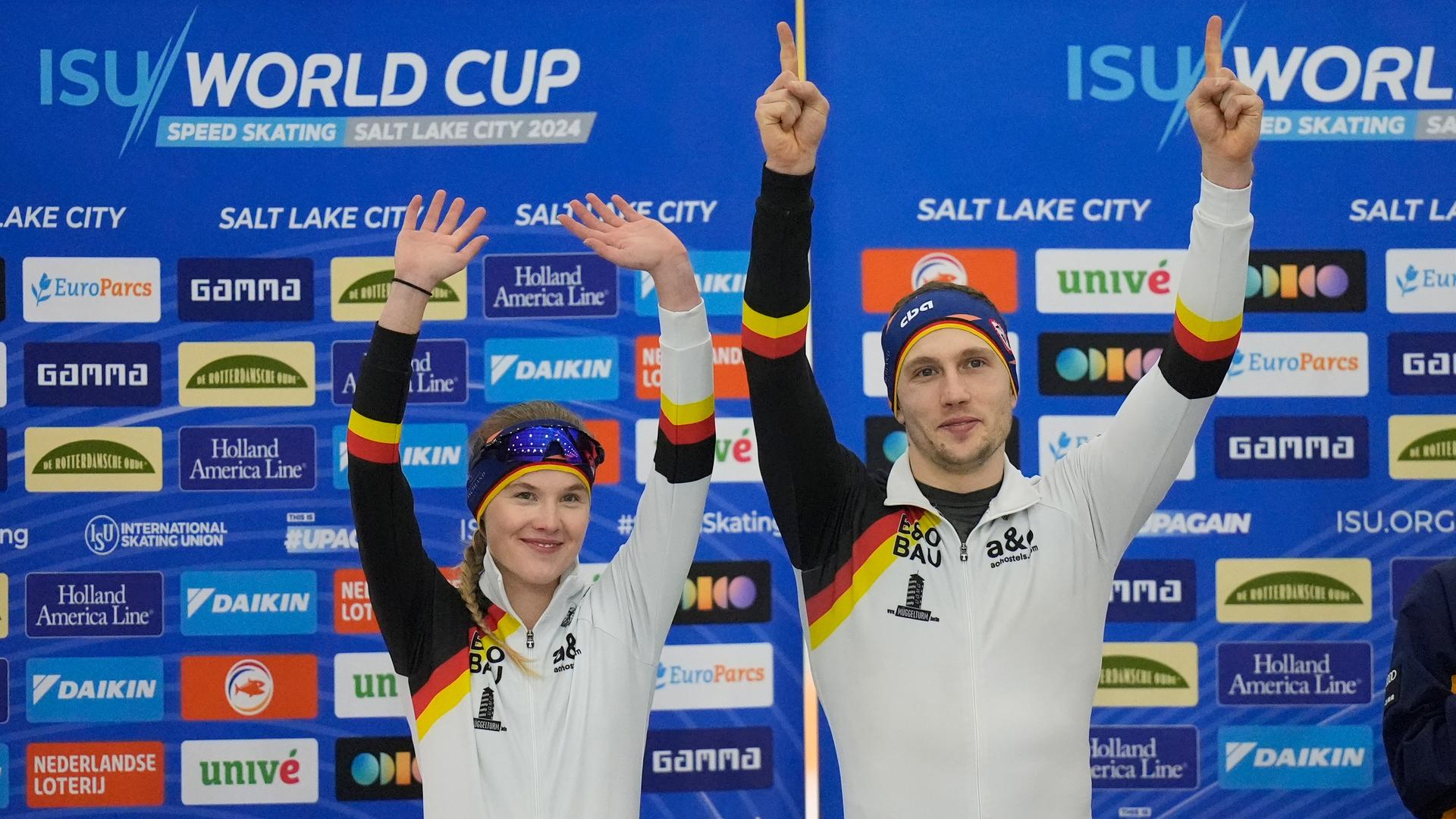 Anna Ostlender und Hendrik Dombrek stehen gemeinsam auf einem Podium und halten ihre Arme in die Luft. Hinter ihnen eine Wand mit vielen Werbelogos. Anna Ostlender und Hendrik Dombrek stehen gemeinsam auf einem Podium und halten ihre Arme in die Luft. Hinter ihnen eine Wand mit vielen Werbelogos.