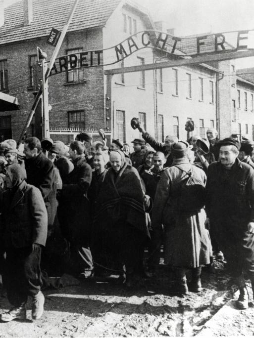 Überlebende von Auschwitz verlassen das Lager. Das Foto wurde von einem sowjetischen Fotografen während der Herstellung eines Films über die Befreiung des Lagers gemacht. 