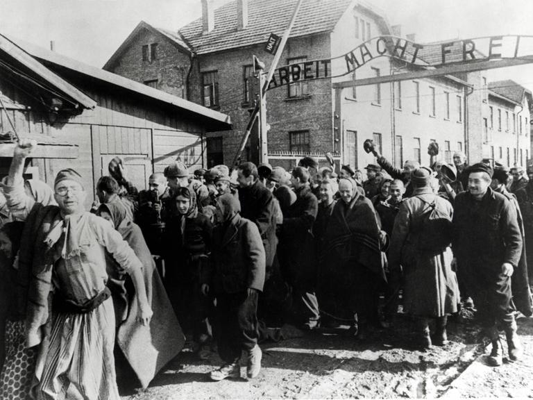 Überlebende von Auschwitz verlassen das Lager. Das Foto wurde von einem sowjetischen Fotografen während der Herstellung eines Films über die Befreiung des Lagers gemacht. 