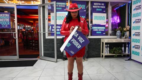 Die hispanische Bürgerrechtlerin Judy Castillo schaut während einer von BOLD DEMOCRATS in Houston veranstalteten Wahlkampfveranstaltung auf ihr Handy. Im Hintergrund: Schilder mit spanischen Losungen "Nuestro Voz, Nuestro Poder" Die hispanische Bürgerrechtlerin Judy Castillo schaut während einer von BOLD DEMOCRATS in Houston veranstalteten Wahlkampfveranstaltung auf ihr Handy. Im Hintergrund: Schilder mit spanischen Losungen "Nuestro Voz, Nuestro Poder"