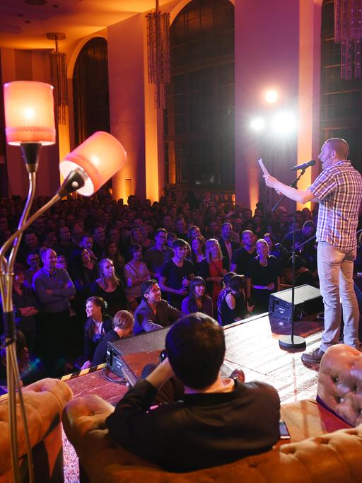 Der Autor Arne Seidel auf einer Bühne vor Gästen