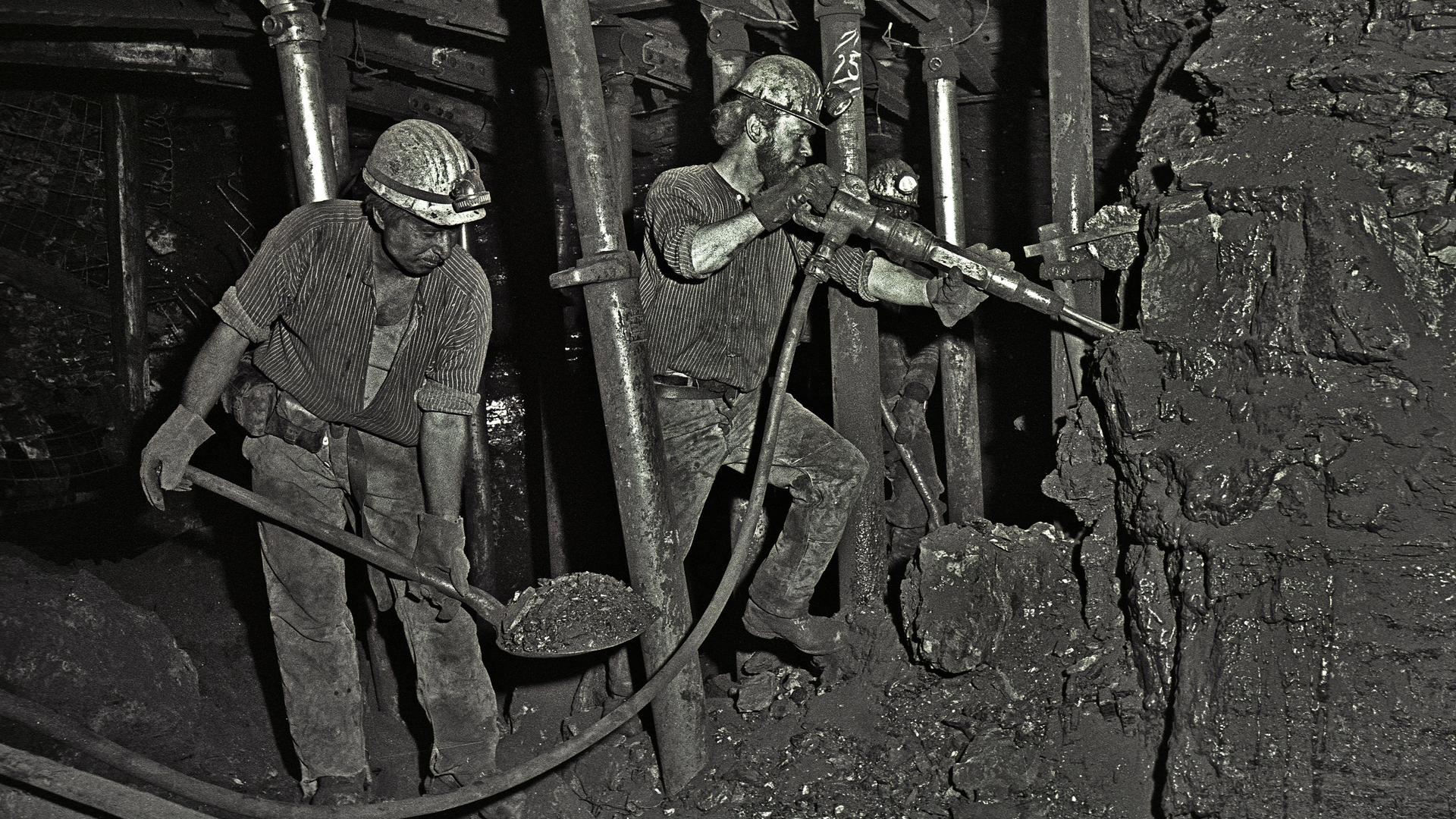 Bergleute bauen mit Presslufthammer und Schaufel auf der Zeche Ewald in Herten Kohle ab.