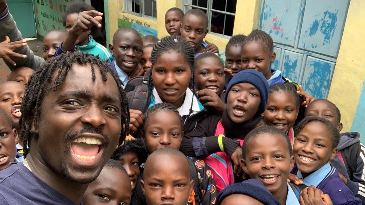 Kevin Ochieng Odour (links) mit Kindern im Slum Kibera in Nairobi. Dort wuchs der Fußballspieler auf.
