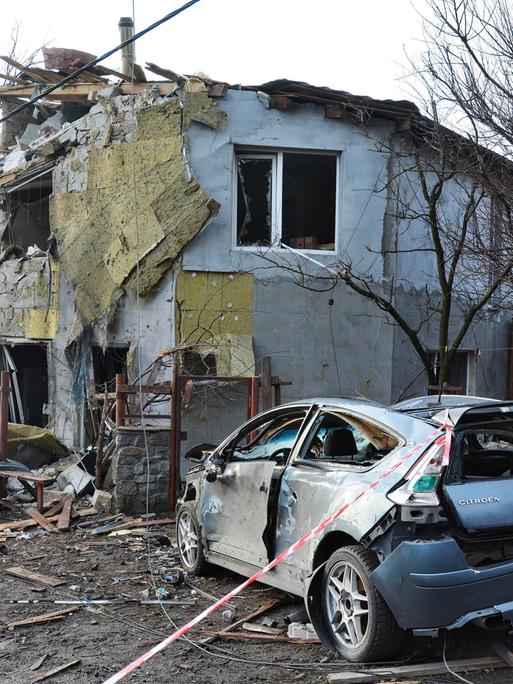 Ein zerstörtes Wohngebäude und ein zerstörtes Auto in Kiew nach einem russischen Raketenangriff