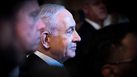 Profilaufnahme von Benjamin Netanjau. Um den israelischen Regierungschef stehen viele Menschen im Schatten.