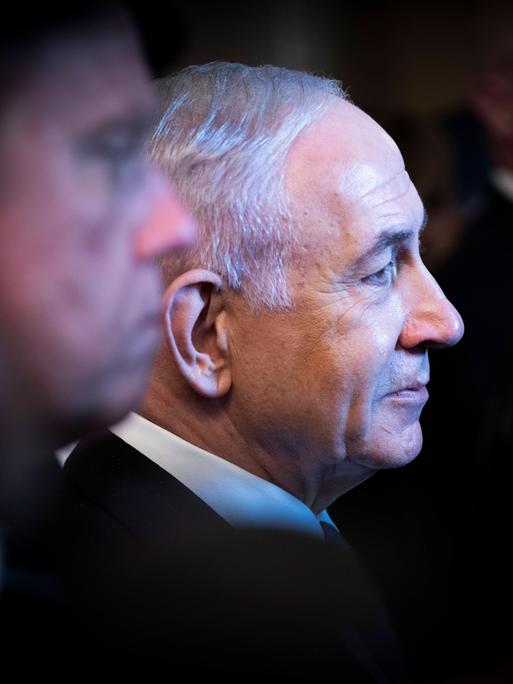 Profilaufnahme von Benjamin Netanjau. Um den israelischen Regierungschef stehen viele Menschen im Schatten.