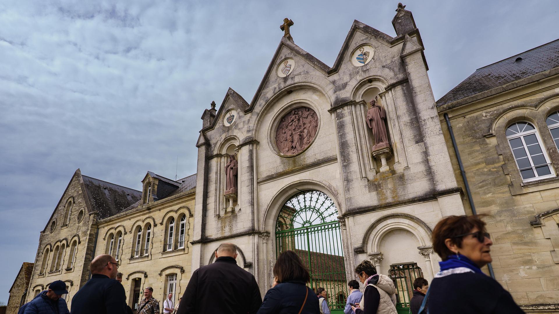Die Besucher warten auf dem Vorplatz der Abtei La Trappe in der Normandie. 