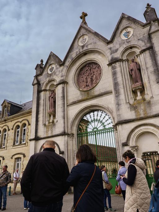 Die Besucher warten auf dem Vorplatz der Abtei La Trappe in der Normandie. 