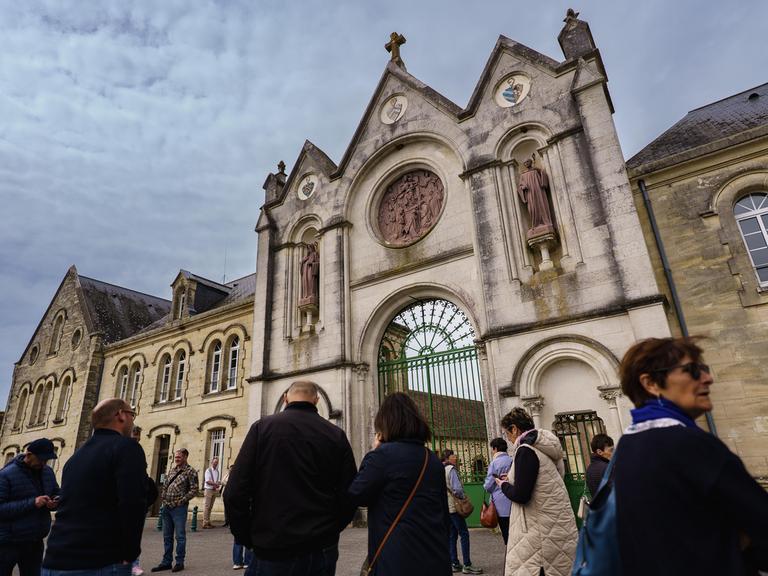 Die Besucher warten auf dem Vorplatz der Abtei La Trappe in der Normandie. 