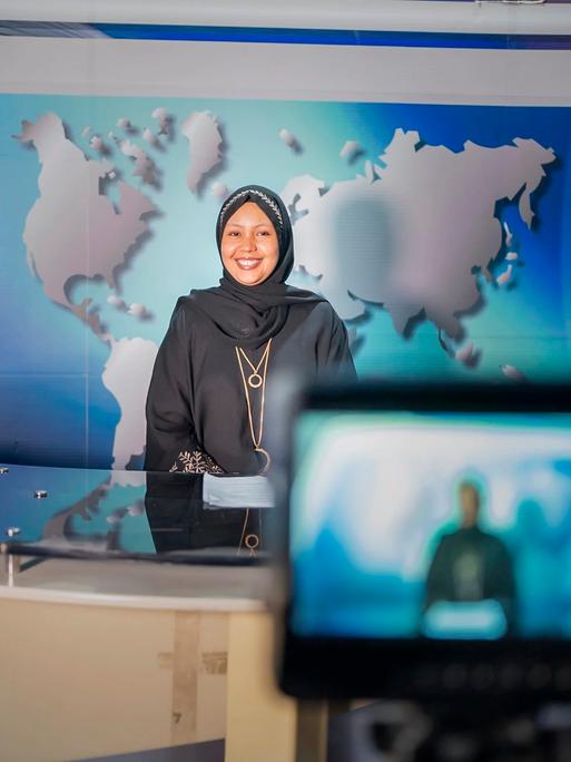 Fathi Mohamed Ahmed, Chefredakteurin von Bilan Media in Somalia, steht in einem Nachrichtenstudio vor der Kamera.