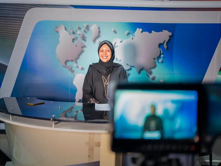 Fathi Mohamed Ahmed, Chefredakteurin von Bilan Media in Somalia, steht in einem Nachrichtenstudio vor der Kamera.