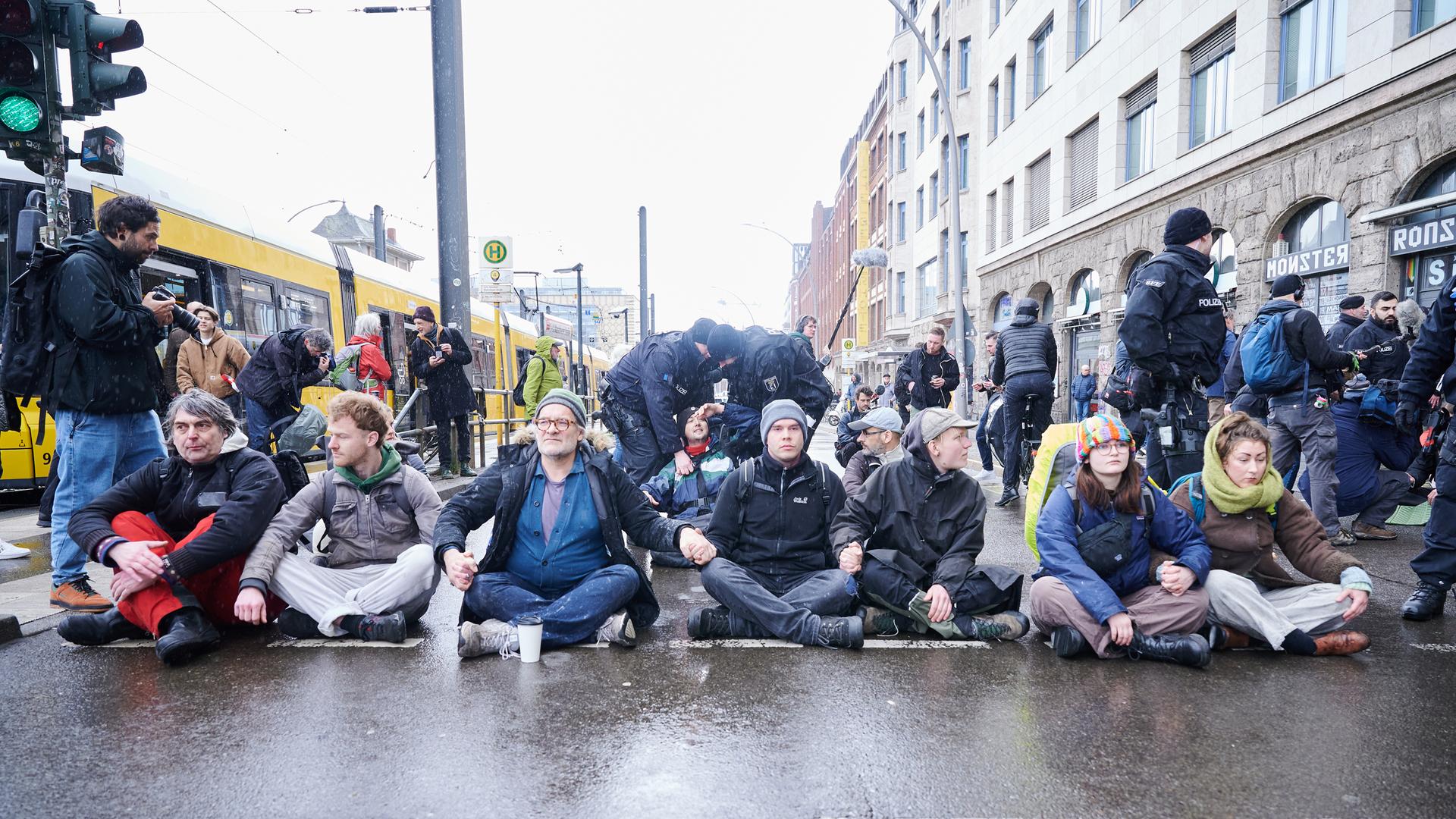 Polizisten ziehen Klimaaktivisten in Berlin von der Straße. 