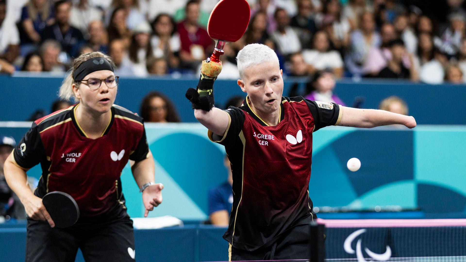 Das deutsche Tischtennis-Doppel steht im Halbfinale; die beiden Spielerinnen in Aktion vor der Tischtennisplatte