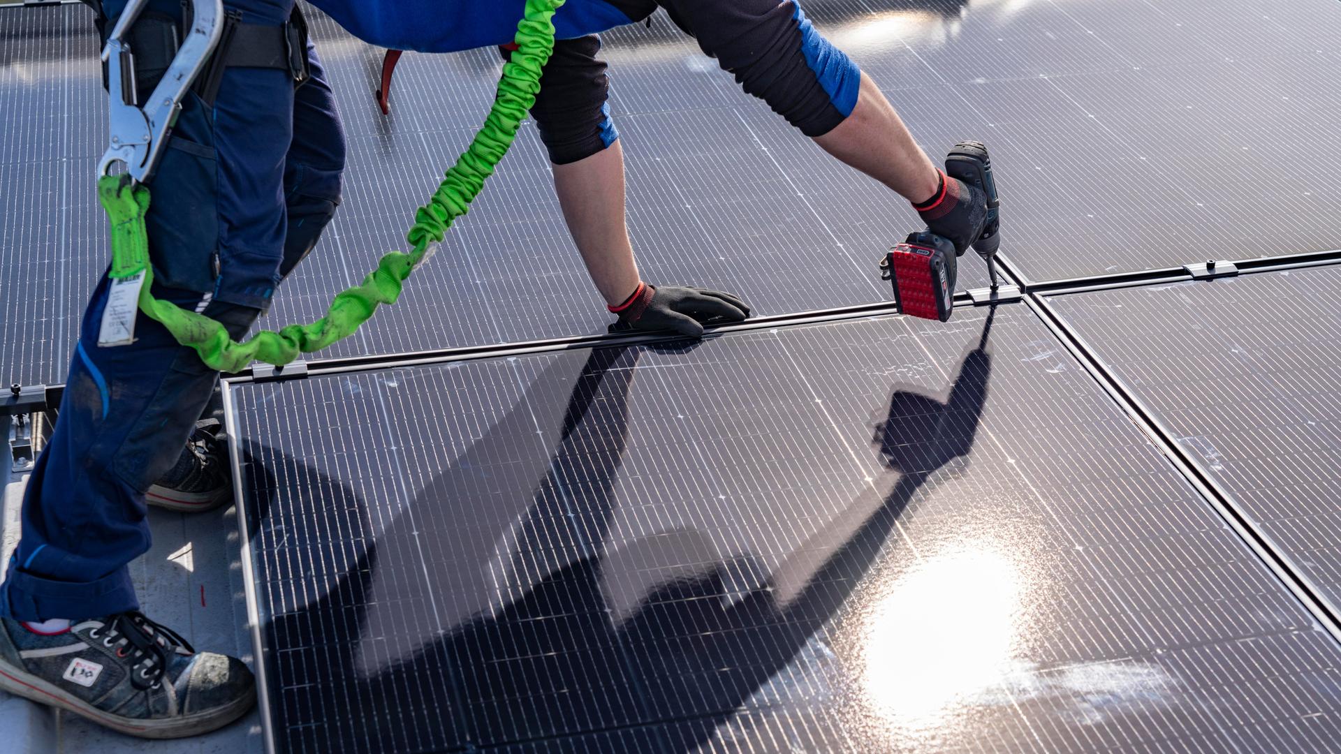 Montage von Solarmodulen auf einem Dach eines Hauses. 
