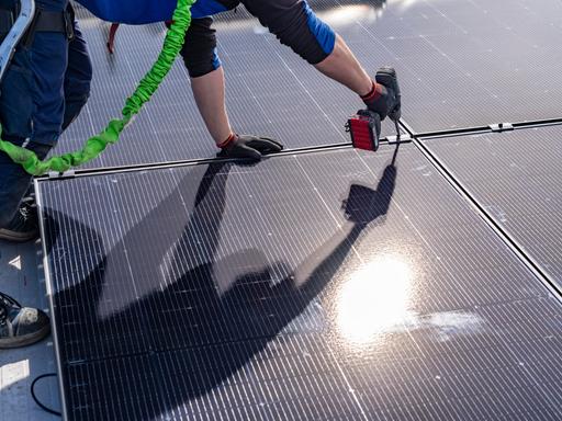 Montage von Solarmodulen auf einem Dach eines Hauses. 