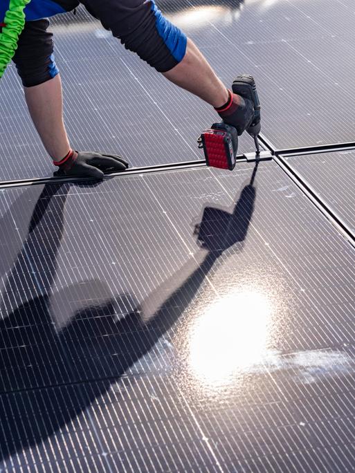 Montage von Solarmodulen auf einem Dach eines Hauses. 