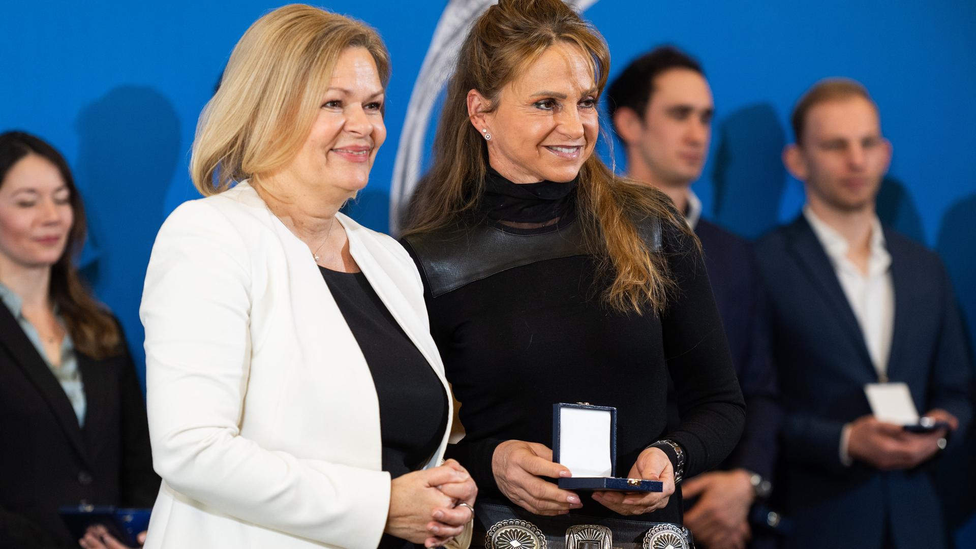 Bundesministerin Faeser überreicht Dorothee Schneider Silberne Lorbeerblatt. Im Hintergrund stehen weitere ausgezeichnete Sportler. Bundesministerin Faeser überreicht Dorothee Schneider Silberne Lorbeerblatt. Im Hintergrund stehen weitere ausgezeichnete Sportler.