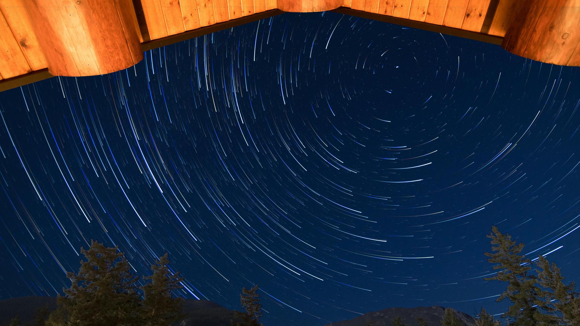 Blick von einer Hütte in den Himmel, auf dem sich kreisende Stern abbilden.