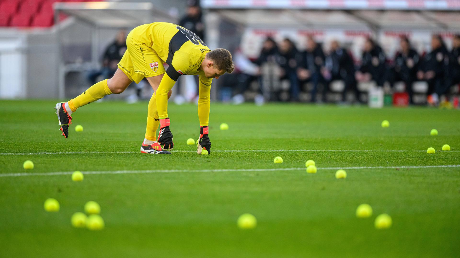 Stuttgarts Torwart Alexander Nübel sammelt Tennisbälle vom Spielfeld.