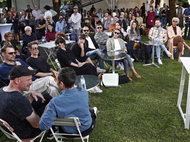 Teilnehmer sitzen bei der Eröffnung der "48. Tage der deutschsprachigen Literatur" in Klagenfurt vor dem Publikum.