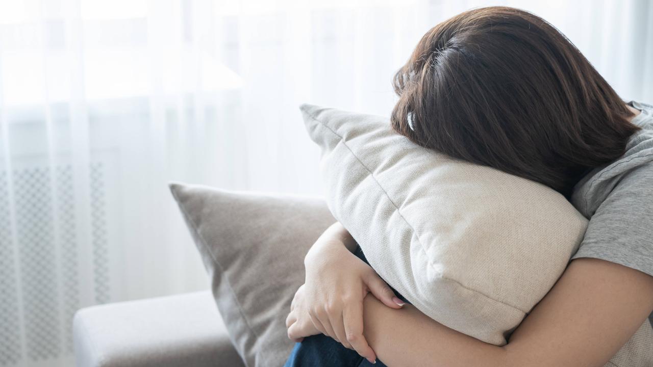 Eine junge Person ruht sich auf einem Sofa aus. 