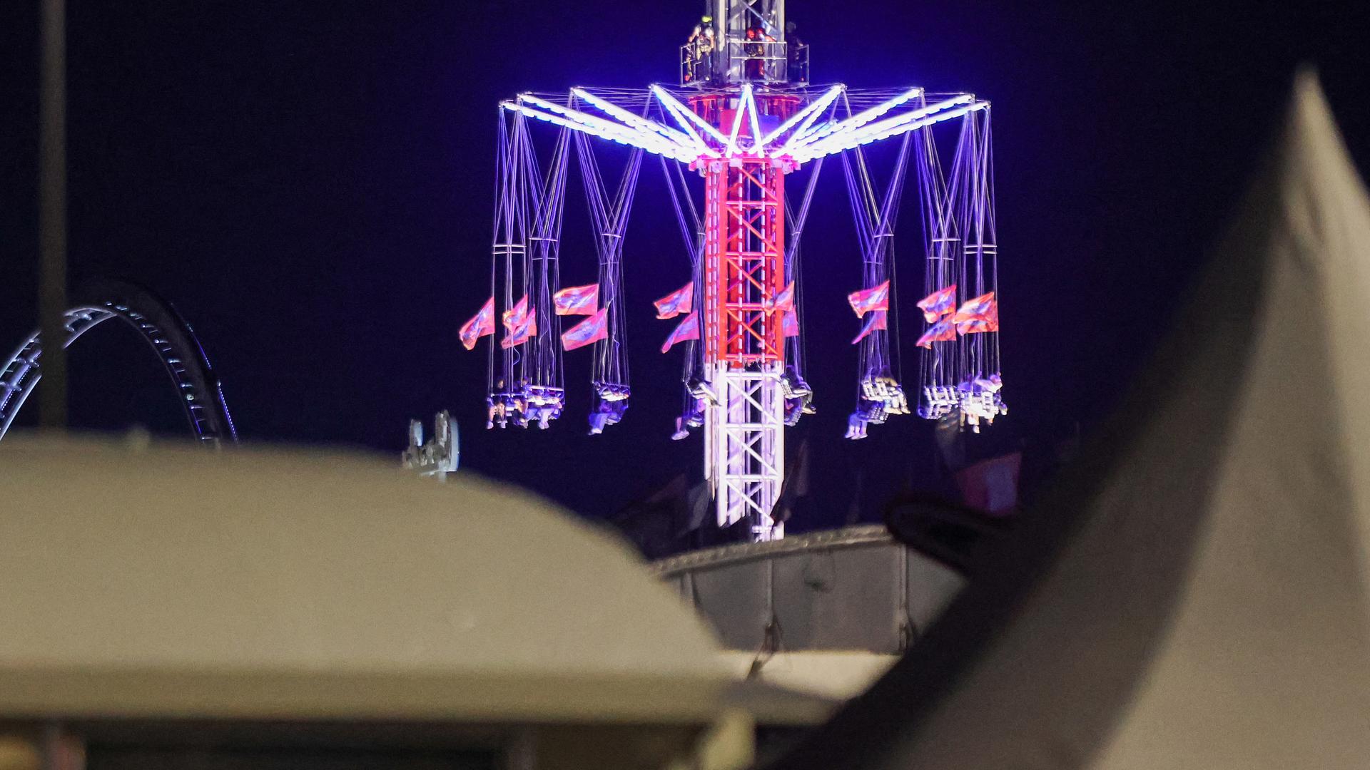 Menschen sitzen in einem Kettenkarussel auf dem Hamburger Dom fest.