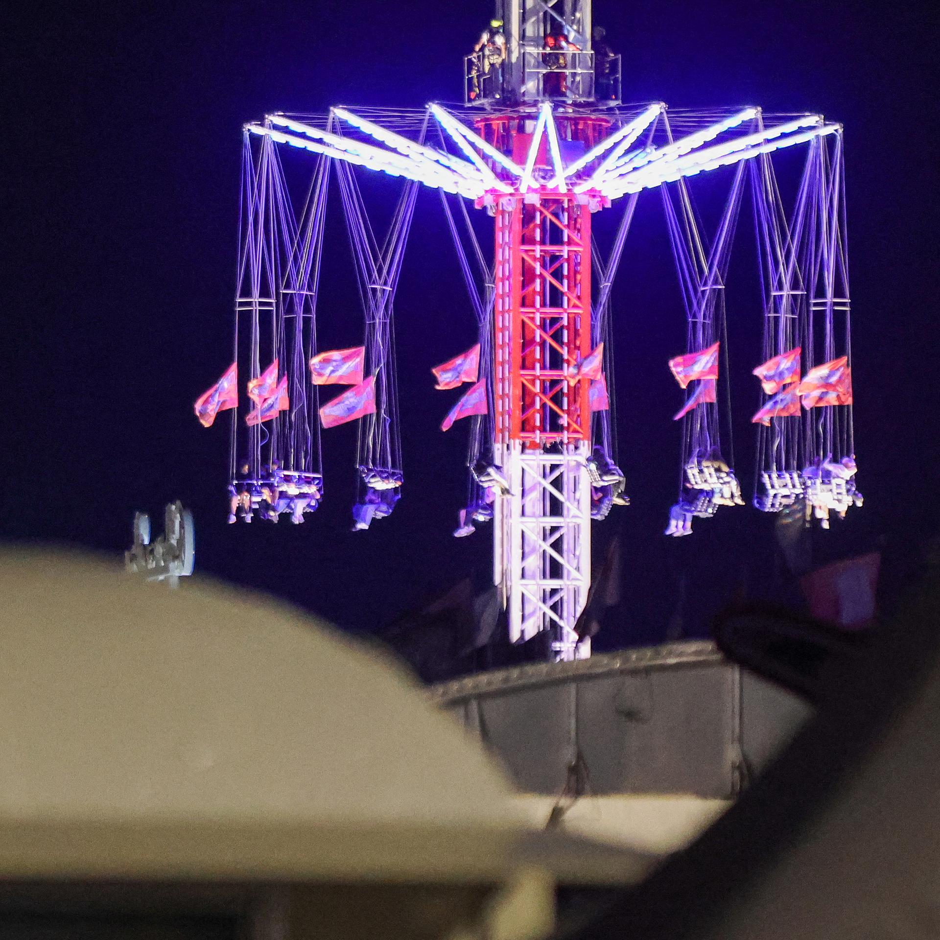 Menschen sitzen in einem Kettenkarussel auf dem Hamburger Dom fest.
