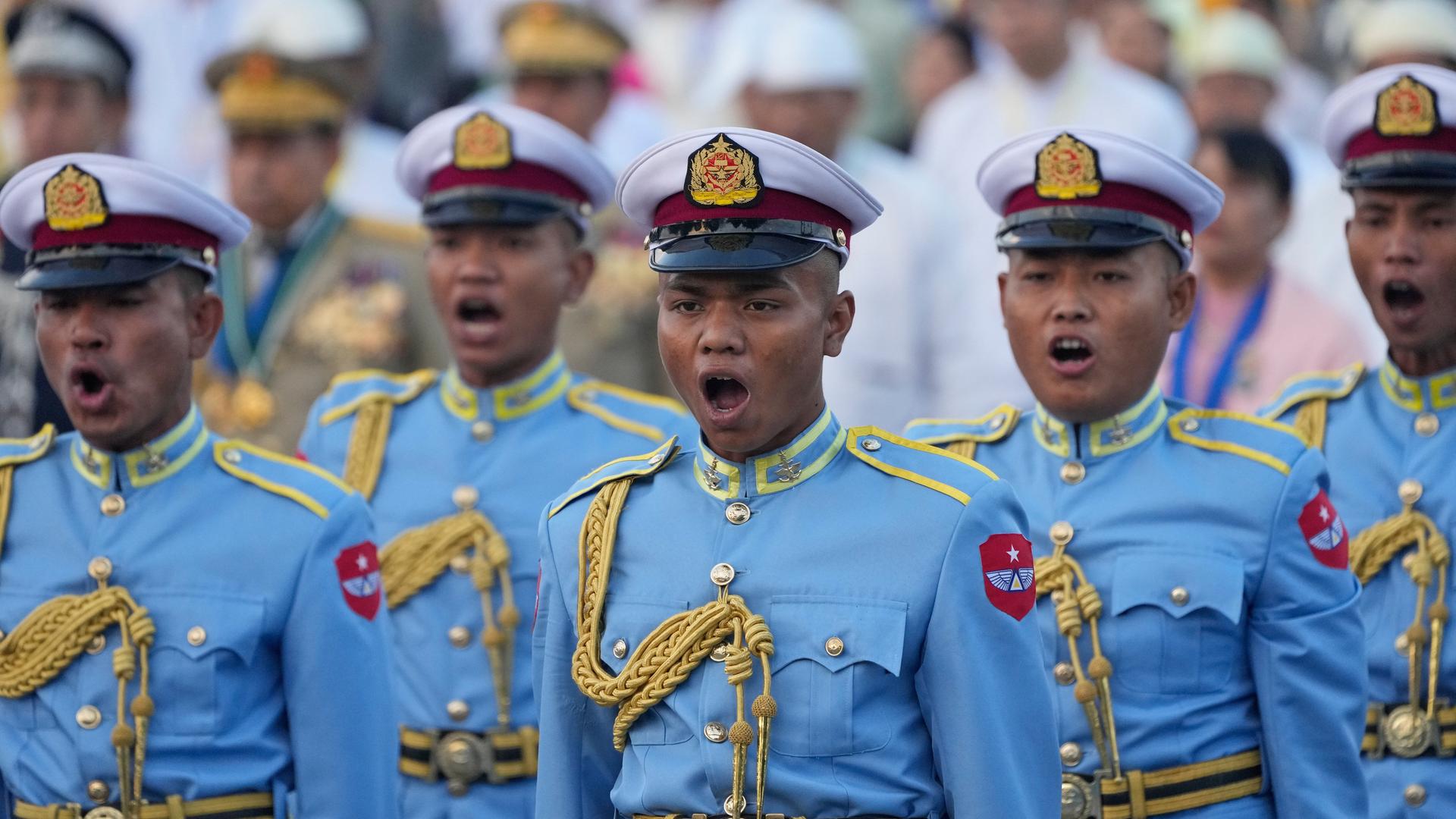 Hochranginge Soldaten in hellblauer Militäruniform stehen nebeneinander und singen. 