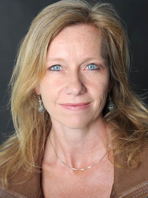 Die Autorin Christine Brand lächelt auf einem Porträt ruhig in die Kamera.